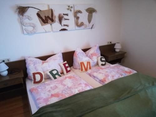 a bedroom with a bed with pillows with the words driftmite at Gästehaus Anna in Grossarl