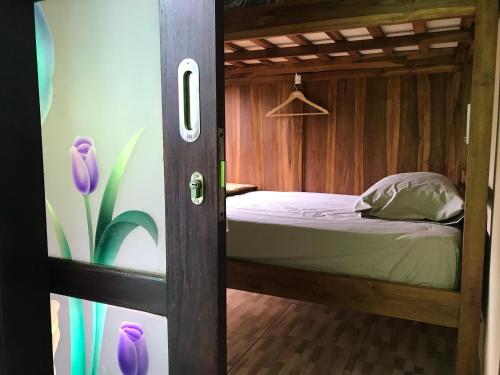 a bedroom with a bunk bed in a wooden room at WW Backpackers in Ubud