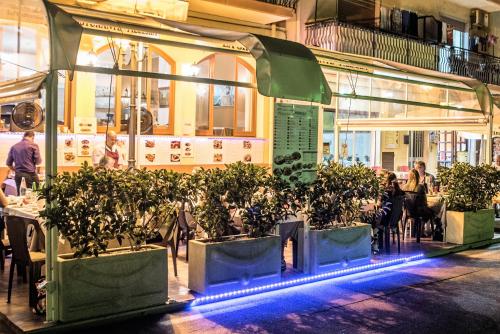 a group of potted plants in front of a restaurant at Hotel La Sirenetta in Giardini Naxos