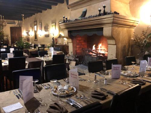 une salle à manger avec une cheminée, des tables et des chaises dans l'établissement Auberge De Pachoquin, à Méounes-lès-Montrieux