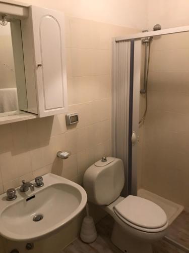 a bathroom with a white toilet and a sink at Hotel La Sirenetta in Giardini Naxos