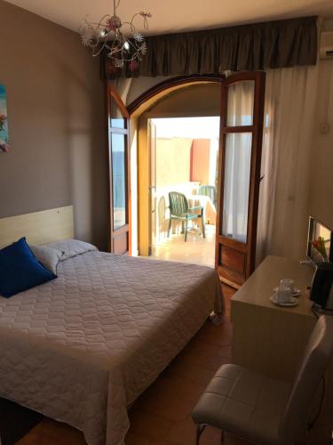 a bedroom with a bed and a table and a chair at Hotel La Sirenetta in Giardini Naxos