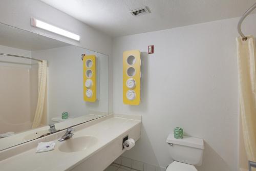 W łazience znajduje się umywalka, toaleta i lustro. w obiekcie Motel 6-Bedford, TX - Fort Worth w mieście Bedford
