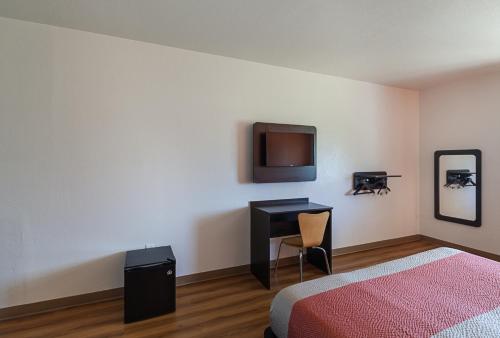 a bedroom with a bed and a desk and a tv at Motel 6-Bedford, TX - Fort Worth in Bedford