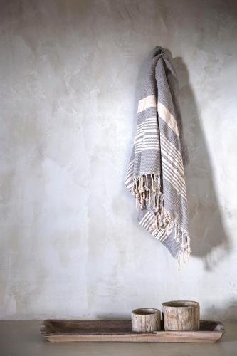a towel hanging on a wall next to two stools at Kymata Bohemian Villas in Lixouri