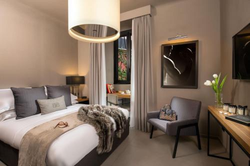 1 dormitorio con cama, escritorio y silla en Parioli Place B&B, en Roma
