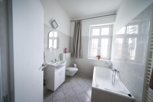 a bathroom with a toilet and a tub and a sink at Bluestars Home in Karlovy Vary
