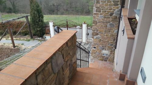 a stone retaining wall with a view of a yard at B&B Podere Montese in Villafranca in Lunigiana