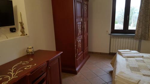 a bedroom with a dresser and a bed and a window at B&B Podere Montese in Villafranca in Lunigiana