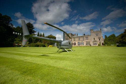 a helicopter sitting on the grass in front of a castle at Armathwaite Hall Hotel & Spa in Bassenthwaite