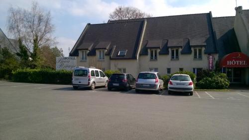 un grupo de autos estacionados en un estacionamiento frente a un edificio en Hôtel Beau Rivage, en Arradon