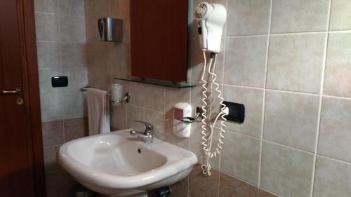 a bathroom with a sink and a phone on the wall at Hotel La Falconara in Castrovillari