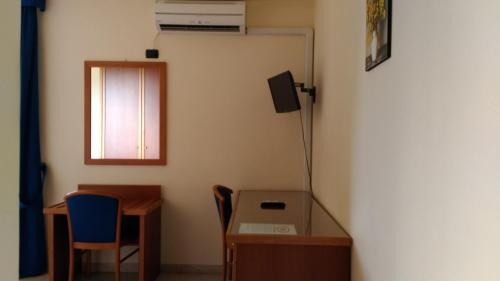 a room with a desk and a table and a window at Hotel La Falconara in Castrovillari
