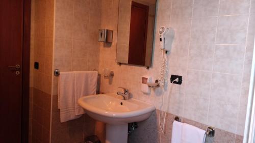 ein Badezimmer mit einem Waschbecken und einem Telefon an der Wand in der Unterkunft Hotel La Falconara in Castrovillari