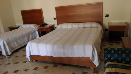 a bedroom with two beds and two night stands at Hotel La Falconara in Castrovillari