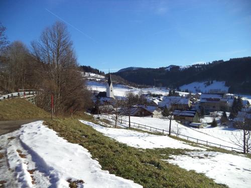 ein kleines Dorf im Schnee mit einer Kirche in der Unterkunft Haus Ritter in Missen-Wilhams