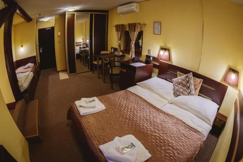a hotel room with a bed and a dining room at Hotel Kaskada in Poprad