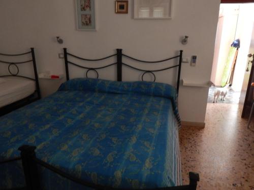 a bedroom with a bed with a blue comforter and a dog at b&b le cote in Giglio Porto