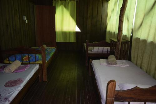 a small room with two beds and a window at Villas Maria Luisa in Uvita