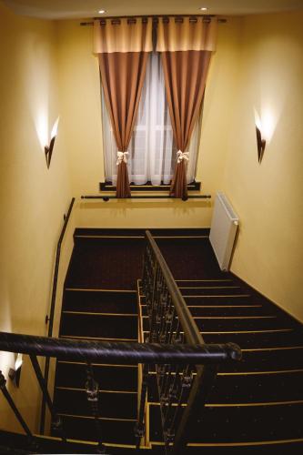 an auditorium with stairs and a window with curtains at Hotel Kaskada in Poprad