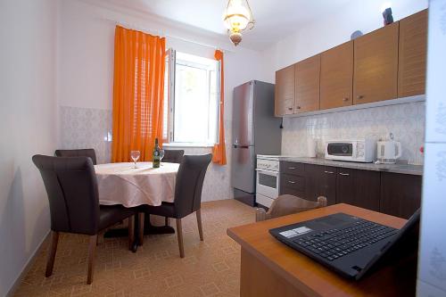 a kitchen with a table and a laptop on a table at Guesthouse Victoria in Dubrovnik