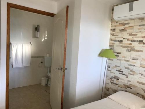 um quarto com uma casa de banho com uma cama e um WC em Golda Sol em Loulé