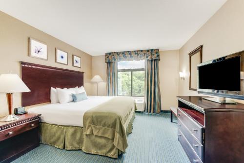 a hotel room with a bed and a flat screen tv at Wingate by Wyndham - York in York