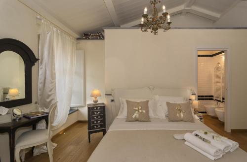 a bedroom with a white bed and a chandelier at B&B Di Camilla in Pisa