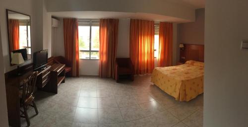 a hotel room with a bed and a television at Hotel Perales in Talavera de la Reina