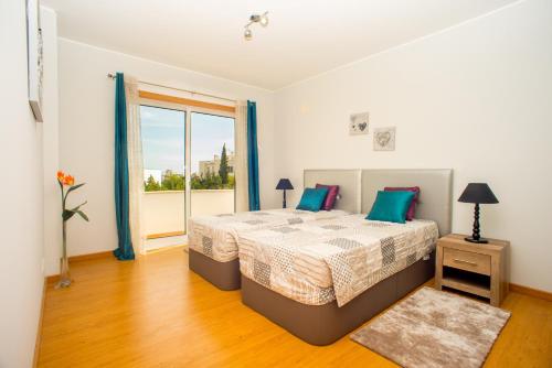 een slaapkamer met een bed en een groot raam bij Pegada By Algartur in Tavira