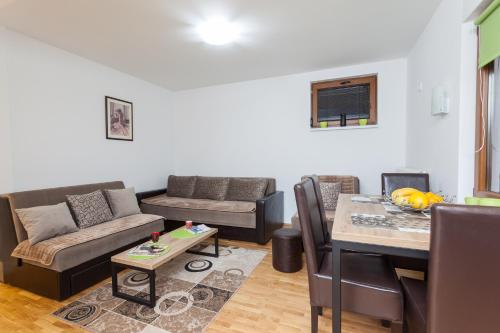 un soggiorno con un divano e un tavolo di Astra Apartment a Zlatibor