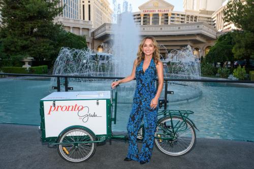 a woman standing next to a bike with a pizza cart at Caesars Palace Hotel & Casino in Las Vegas