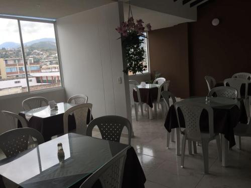 a dining room with tables and chairs and a window at Hotel Marialu in Ocaña