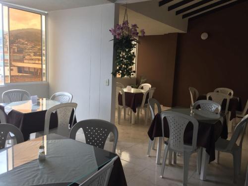 a dining room with tables and chairs and a window at Hotel Marialu in Ocaña