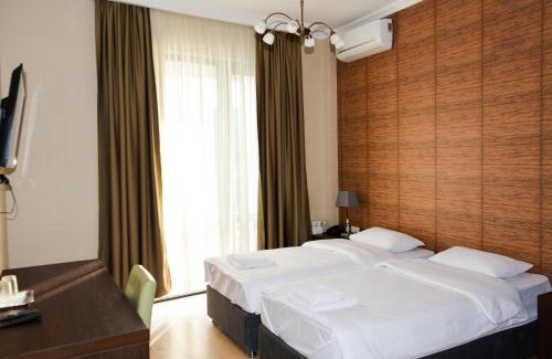ein Hotelzimmer mit einem großen Bett und einem Fenster in der Unterkunft Eleon Boutique Hotel in Tbilisi City