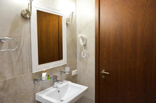 a bathroom with a sink and a wooden door at Eleon Boutique Hotel in Tbilisi City