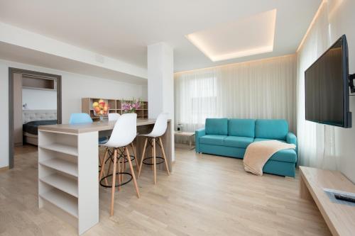 a living room with a blue couch and a table at 8ERA Business Executive Rotermanni Apartments in Tallinn