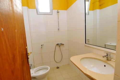 y baño con lavabo, aseo y ducha. en Résidence De La Porte Du Millenaire, en Dakar