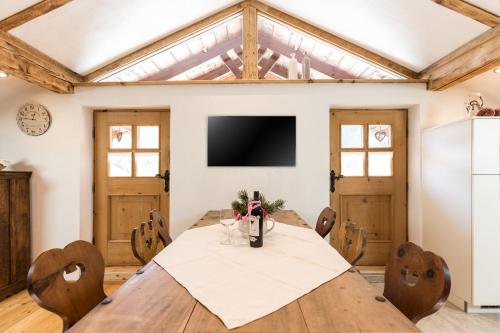 a dining room with a table and a tv at Buxgarten Ferienhof in Oetz