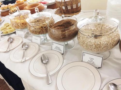 a table topped with white plates and bowls of food at Itu Plaza Hotel in Itu