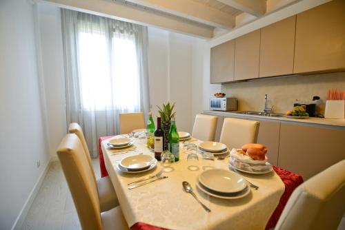 a dining room table with chairs and a table with food on it at Residence La Fontaine in Venice-Lido
