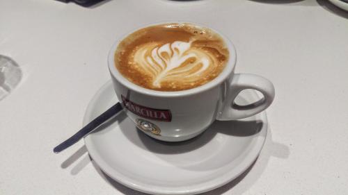 a cup of coffee on a plate on a table at Hospedería Santa Elena in San Carlos del Valle