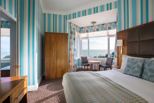 a hotel room with a bed and a view of the ocean at Hydro Hotel in Eastbourne