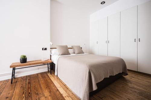 a white bedroom with a bed and a wooden floor at Bella Easo - Iberorent Apartments in San Sebastián