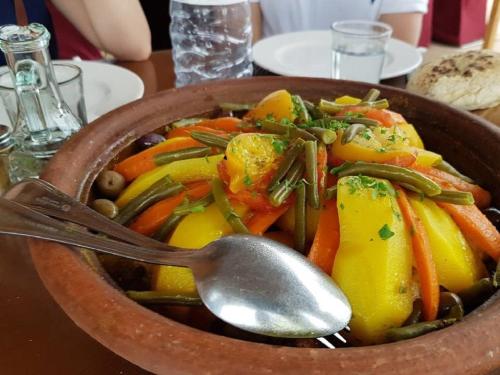 a bowl of vegetables with a spoon on a table at Terres d'Amanar in Tahannout