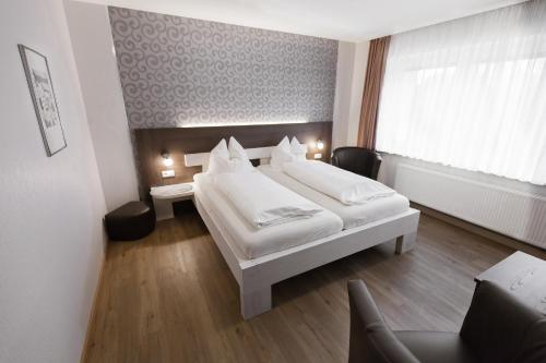 a bedroom with two white beds and a window at Gästehaus Wein im Turm in Longuich