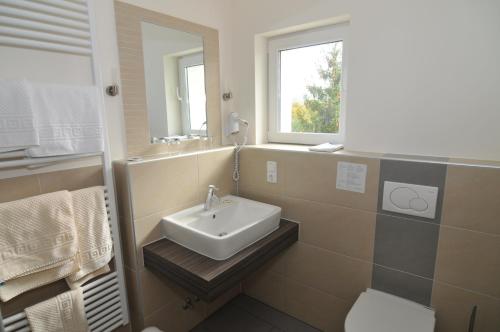 uma casa de banho com um lavatório, um WC e um espelho. em Gästehaus Wein im Turm em Longuich