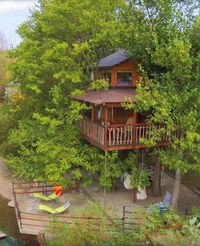 a tree house with a deck in the trees at Holiday Home Kućica Na Drvetu in Banja Koviljača