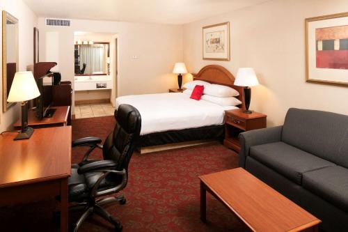 a hotel room with a bed and a desk and a couch at Red Lion Hotel and Conference Center St. George in St. George
