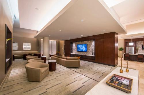 a lobby of a hotel with couches and a tv at National at Tysons Corner in Howard